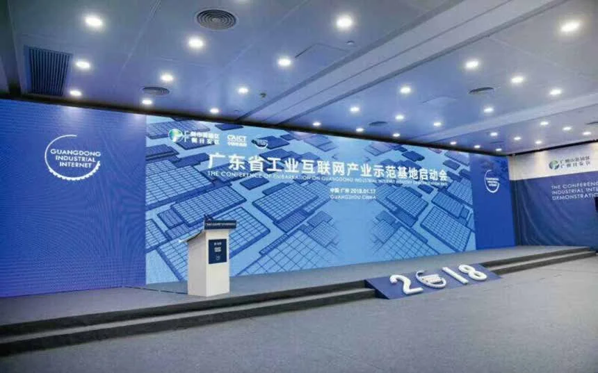 广东省工业互联网协会成立大会:协会成立大会的蓝色主题背景与发言台